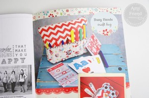 Busy Hands craft bag with colorful supplies on a rustic blue table.