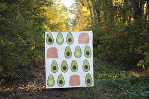 Modern quilt featuring paper pieced avocado quilt blocks and toast quilt blocks, held in a fall landscape.